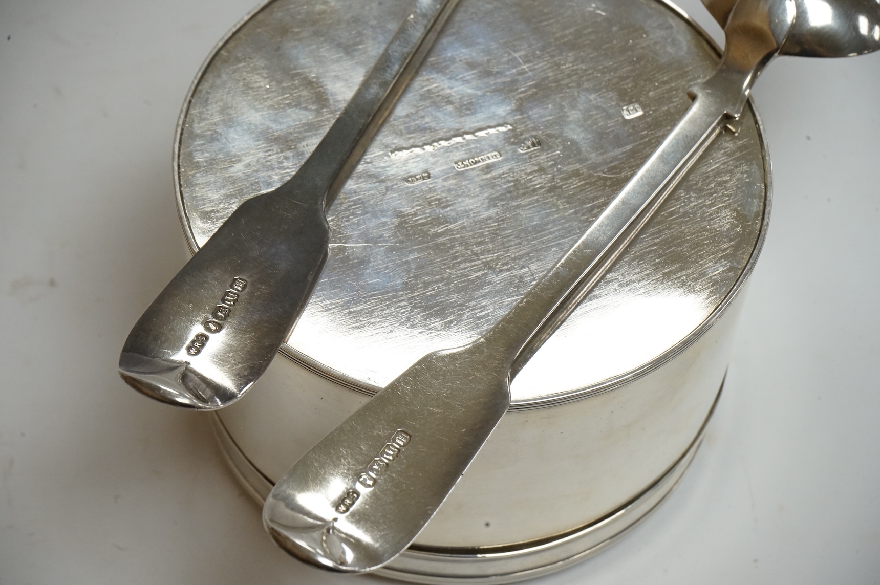 An early 19th century Dutch white metal circular biscuit box, with hinged cover and reeded bands, maker IT, retailed by Diemont, height 78mm, together with a pair of Victorian silver fiddle pattern table spoons by Willia